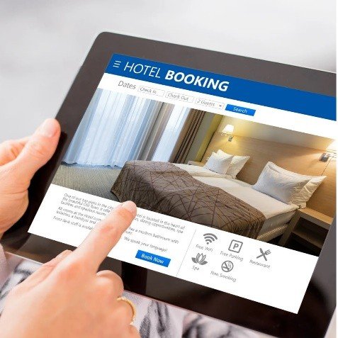 Seseorang sedang melakukan hotel reservation untuk personal dan corporate di tablet.