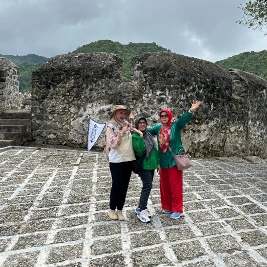 Seorang tour leader profesional & berpengalaman sedang memandu grup wisata.