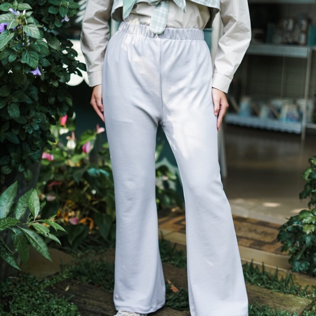 Detail outfit celana kulot abu-abu dengan outer rompi kotak-kotak hijau.